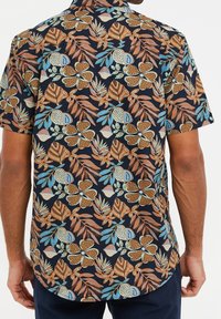 Korte mouwen shirt met een donkere achtergrond en een levendig bloem- en bladerenpatroon in tinten blauw, oranje en groen. Gemaakt van katoen.