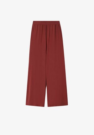 Pantalon à jambes larges de couleur rouille unie avec taille élastique et poches sur les coutures latérales, en tissu lisse.