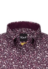 Lila Blumenshirt mit detaillierten weißen und pinken Blumenmustern auf einem weichen Stoff, mit einem strukturierten Kragen und einem Markenlabel.