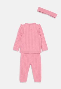 Completo in maglia rosa con un motivo a treccia, top a maniche lunghe con dettagli a volant, pantaloni abbinati e una fascia per capelli coordinata.
