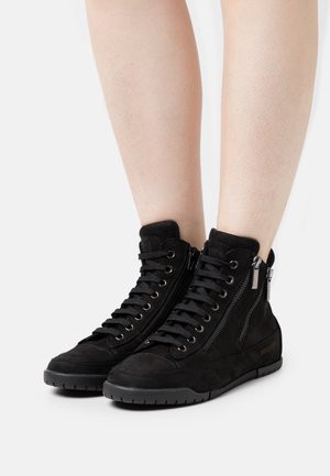 Černé semišové vysoké tenisky s textura povrchem, šněrováním v přední části a bočními zipovými akcenty, s flexibilní gumovou podrážkou.