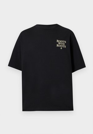 Crna majica kratkih rukava s bež natpisom "BOOTSA WITH ROOTS" i malim logom stabla na gornjem lijevom dijelu prsnog koša.