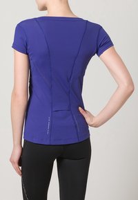 Maglietta sportiva viola con maniche corte, dotata di un design posteriore testurizzato, cuciture a contrasto e dettagli riflettenti all'orlo.