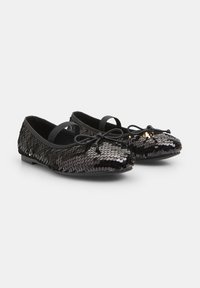 Black ballet flats covered in shiny, overlapping sequins, featuring a soft texture, rounded toe, and a bow accent on the front.