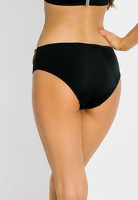 Czarne bikini z wysokim stanem wykonane z gładkiego materiału, z małym ozdobnym akcentem z boku. Klasyczny, jednolity design z minimalnym szwem.