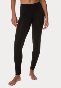 Černé legíny vyrobené z měkké, elastické tkaniny s přiléhavým střihem a bez viditelných švů, s elastickým pasem pro pohodlné nošení.