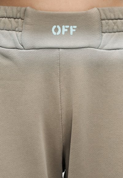 Μπεζ παντελόνι με ελαστική μέση και τη λέξη "OFF" τυπωμένη με λευκά γράμματα στο κέντρο της πίσω πλευράς.