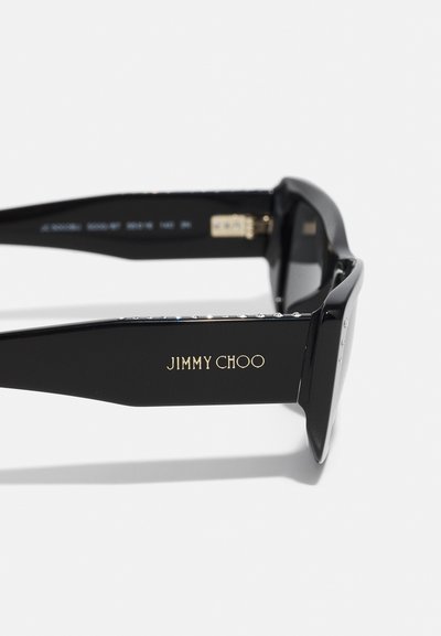 Ochelari de soare negri cu un finisaj lucios, având textul auriu "JIMMY CHOO" și împodobiți cu strasuri clare pe pârtiile lentilelor.