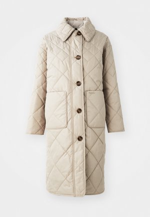 Beige tepitud mantel kõrge kraega, millel on neli pruuni nuppu, kaks esist pocketit ja neutraalne õmblus. Sile tekstuur ja rombikujuline muster.