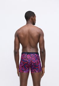 Férfi boxeralsó élénk rózsaszín és kék paisley mintával, puha, rugalmas anyagból készült, fekete gumis derékkal.