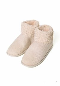Béžové pletené pantofle s texturovaným tělem a nadýchaným, curled fleecovým límcem. Zaoblený design špičky s plochou podrážkou pro vnitřní nošení.