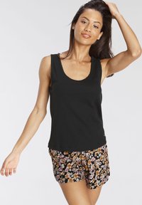 Black ribbed tank top featuring a scoop neckline, paired with floral-patterned shorts in black, orange, and purple tones.