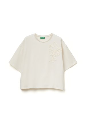 Krémově bílý krátký top s kulatým výstřihem a vyvýšenou květinovou výšivkou na levé straně hrudi, štítek s nápisem United Colors of Benetton.