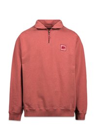 Sweatshirt rouge avec un col montant, une demi-zip et un patch logo carré sur la poitrine gauche. Les poignets et l'ourlet côtelés ajoutent de la texture.