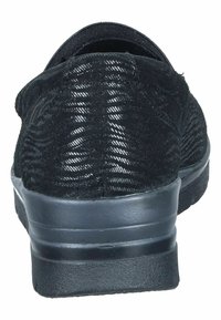 Black sneaker with a textured, fabric upper and a sturdy rubber sole. Features a padded collar and a flat heel, offering a sleek design.