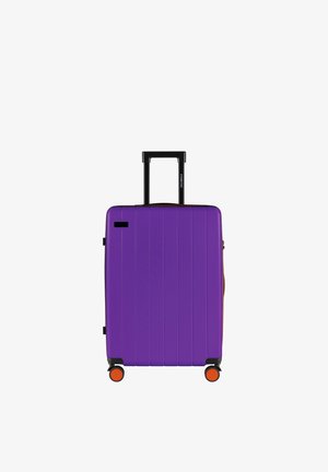 Paars harde koffer met verticale groeven, intrekbare zwarte greep en oranje wielen. Compact ontwerp voor reiskomfort.