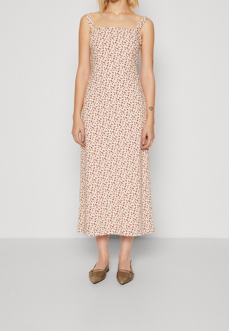 Vestido midi blanco con estampado floral en rojo, escote cuadrado y tirantes finos, confeccionado en un tejido ligero con una textura suave.