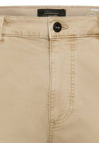 Beige Baumwollhose mit Knopfverschluss, geradem Schnitt, sichtbaren Nähten und einer Seitentasche auf der linken Seite.