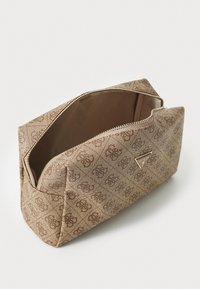 Brown patterned cosmetic bag with a rectangular shape, fabric exterior, zip closure, and a gold logo accent on the front. Interior is smooth.