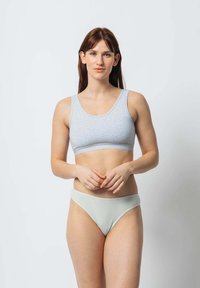 Szary bawełniany biustonosz typu braletka z szerokimi ramiączkami i miękkim pasem w talii, zestawiony z jasnymi miętowymi majtkami bikini. Gładka faktura; minimalistyczny design.