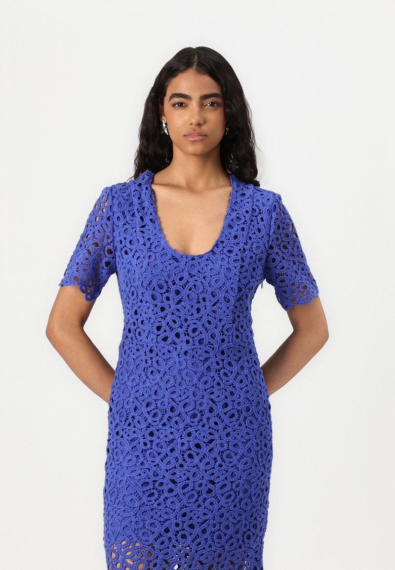 Königblaues Häkelkleid mit kurzen Ärmeln, das einen Rundhalsausschnitt und kunstvolle Blumenmuster auf dem gesamten Stoff zeigt.