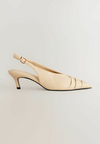 Beige lodičky na podpatku s špičatou špičkou, vyrobené z hladkého materiálu. Mají jemný řasený design a 5 cm nízký podpatek. Nastavitelný pásek.