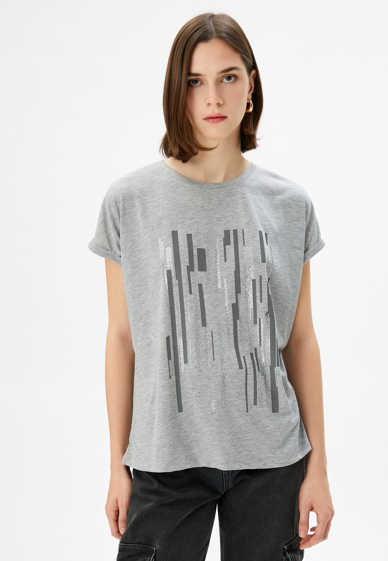 Grå kortærmet T-shirt lavet af blødt bomuld, med et vertikalt grafisk design i forskellige nuancer af grå og sølv, i en løs pasform.