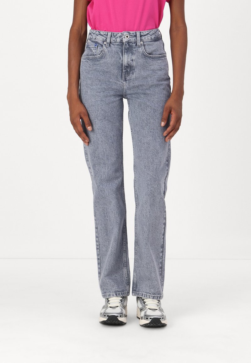 High-waisted, light blue denim jeans with a straight fit, featuring front pockets and a button closure. Pairing with gray sneakers.