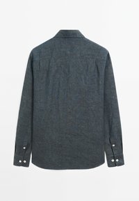 Button-up shirt in dark blue textured fabric with long sleeves, pointed collar, and white button details on the cuffs.