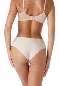 Biancheria intima beige con un design liscio e senza cuciture. Aperture delle gambe a vita alta e una cintura morbida. Tessuto leggero con finitura opaca.