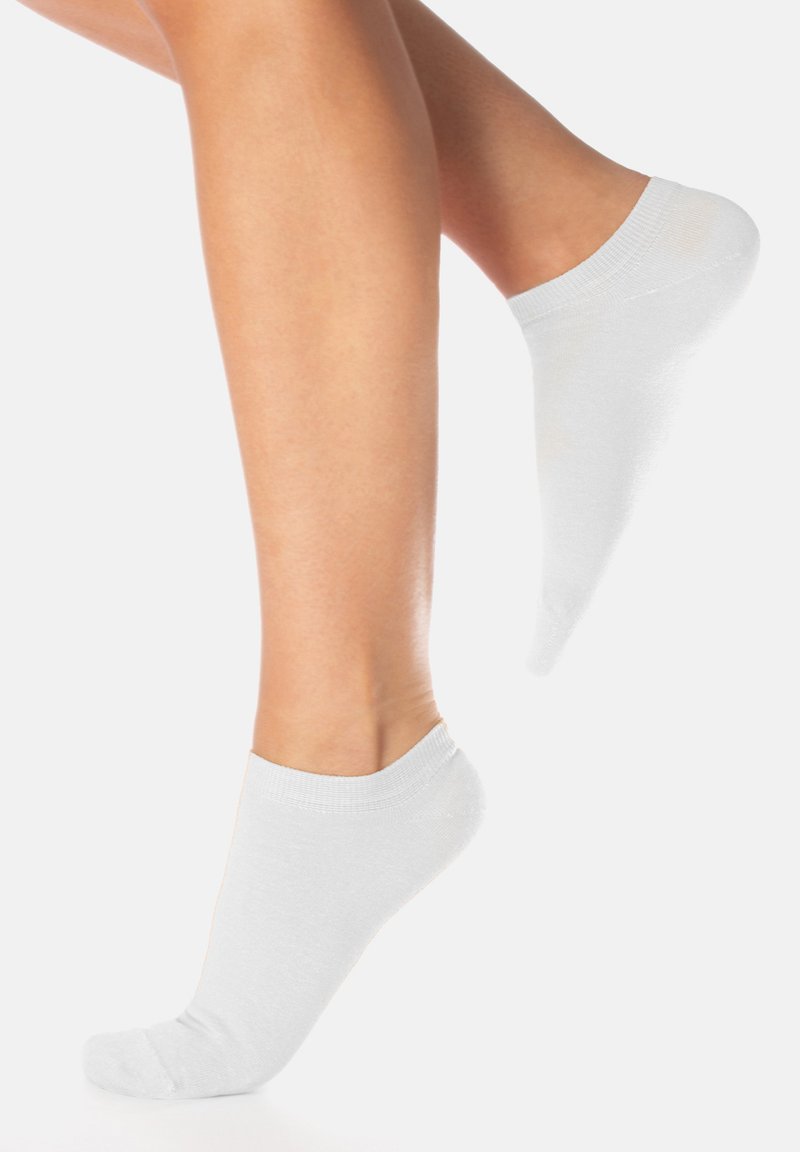 Calze alla caviglia bianche realizzate in un materiale morbido e elasticizzato. Design a taglio basso con un bordo a costine e senza pattern o decorazioni.