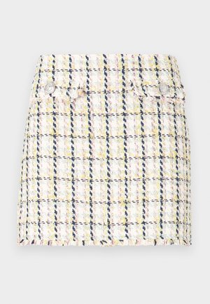 Tweed miniskjørt med flerfarget rutemønster, frynset kant og to metalliske knappeaksenter på framsiden.