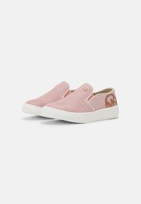 Slip-on sneakers med rosa vävt tyg, vita gummisulor och en brun logotypdetalj på hälen mot en enkel vit bakgrund.