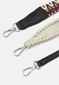 Trzy paski do torebek wykonane z czarnej i kości słoniowej skóry. Czarny pasek ma gładką fakturę, natomiast pasek w kolorze kości słoniowej jest pleciony. Każdy z nich wyposażony jest w metalowe klipsy.