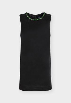 Schwarzes ärmelloses Kleid mit einem Juwelen-verzierten Ausschnitt, der grüne Edelsteine zeigt. Glatter Stoff und ein Reißverschluss am Rücken.