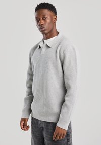 Harmaa neulepusero, jossa on kauluksellinen pääntie, pitkät hihat ja ribbireunat. Sisältää teksturoitua kangasta ja rentoa istuvuutta.