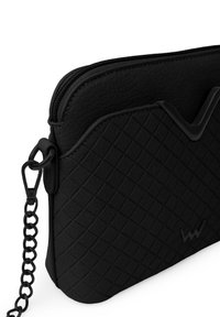 Black leather crossbody bag with a quilted pattern, smooth texture, zip closure, and a chain strap. Features a wave-shaped accent on top.