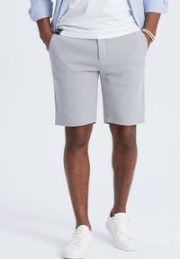 Graue Shorts aus einem glatten, leichten Material, mit einem klassischen Schnitt, Seitentaschen und einem sauberen, minimalistischen Design.