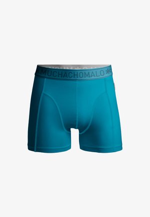 Pánske boxerky v odtieni teal, vyrobené z hladkej, elastickej tkaniny. Majú šedý pás so značkou "MUCHACHOMALO", priliehavý strih a ploché švy.