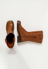 Botas de tobillo de cuero marrón con textura suave, punta cuadrada, tacón bajo en bloque, cierre de cremallera en el lado y tira en la parte posterior.