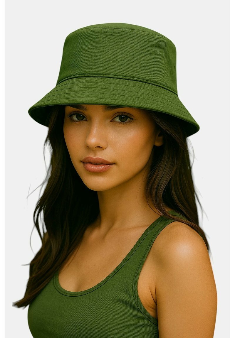 Cappello a secchiello verde realizzato in tessuto strutturato, con tesa larga e corona strutturata, abbinato a una canotta verde coordinata.