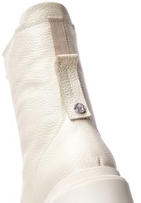 Bottine en cuir blanc avec finition texturée, panneau latéral élastique, détail en métal argenté et semelle en caoutchouc. Surface lisse avec des accents minimes.