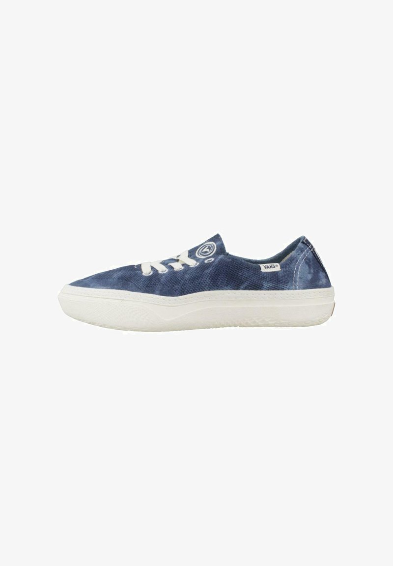 Zapatillas de lona en azul oscuro con suelas y cordones de goma blanca. Presentan un logo redondo y un diseño minimalista. Silueta de corte bajo.
