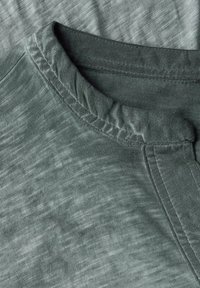 T-shirt in cotone grigio con una finitura morbida e testurizzata. Caratterizzato da un collo rotondo e cuciture rinforzate per una maggiore durabilità.