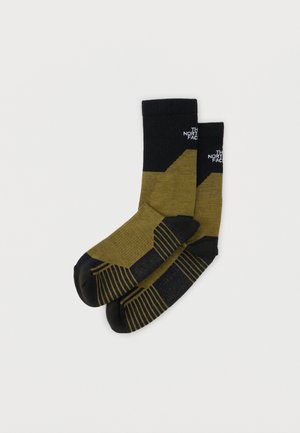 Paire de chaussettes mi-mollet vert olive et noir avec orteils et talons renforcés, arborant le logo The North Face près du bord supérieur.