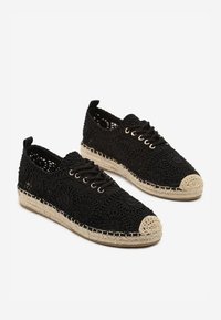 Chaussures noires à lacets avec un design floral brodé, semelle en corde de jute et bout en couleur crème. Comprend des œillets ronds et une tige texturée.