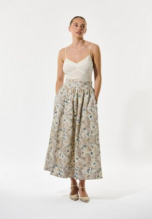 Let, cremefarvet top med tynde stropper kombineret med en blomsterprintet, ankellang nederdel med blå og beige mønstre samt sidelommer.