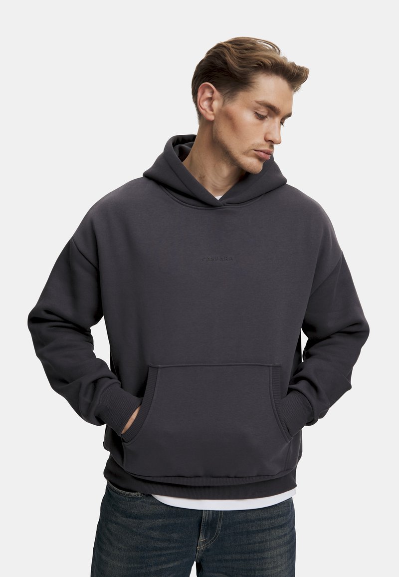 Mörkgrå hoodie i mjukt bomullsblandat material, med ficka fram och ribbad mudd. Diskret logotyp på bröstet, avslappnad passform.