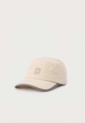 Casquette 66° North beige clair avec une visière courbée grise posée sur une surface blanche.