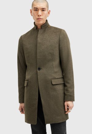 Cappotto di misto lana verde oliva con colletto alto, chiusura a un bottone e due tasche frontali. Presenta una vestibilità sartoriale e una texture liscia.